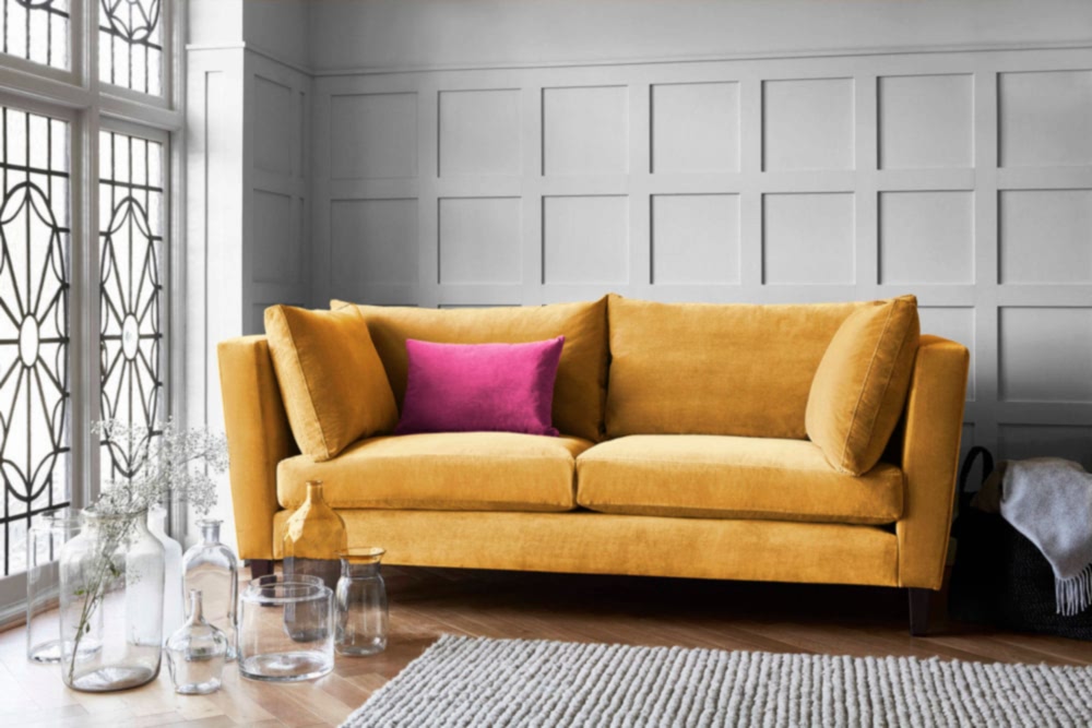 Mustard yellow sofa with high arms to show bright colours trend in 1950s interior design