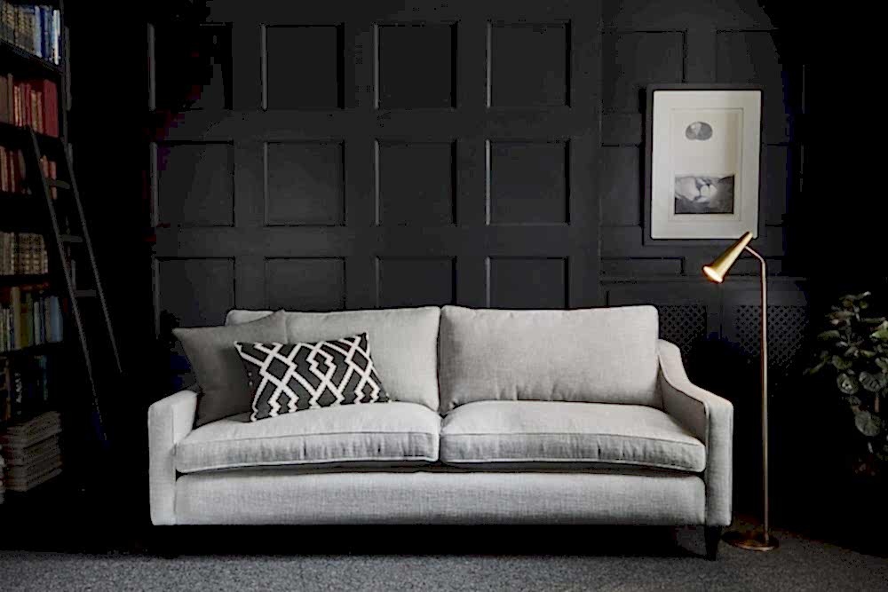 Mid-century modern interiors grey sofa with black feature wall and bookcase to show retro style living room